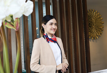 Beautiful Asia reception woman on front at hotel for welcome customer in holiday weekend.