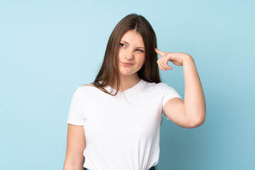 Fototapeta premium Teenager caucasian girl isolated on blue background making the gesture of madness putting finger on the head