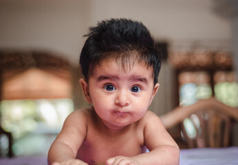 Cute baby girl turning for the first time and looking at the camera, four months old cute daughter...