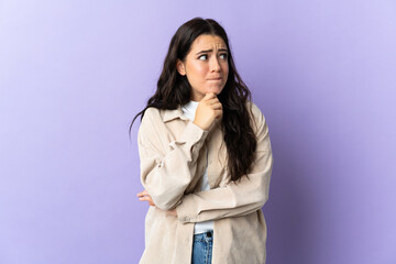 Young caucasian woman isolated on purple background having doubts and thinking