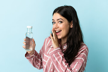 Young woman with a water isolated on blue background whispering something