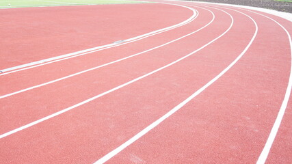 Running track in red with a carbon coating around the stadium with white dividing stripes