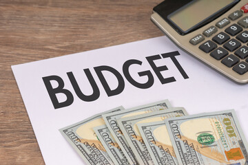 budget paper document with dollar banknotes and calculator