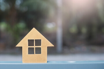 Obraz na płótnie Canvas A cardboard cutout of a house model with greenery background