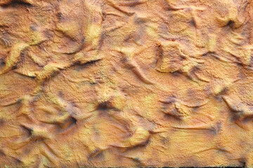 Elements of architectural decoration of buildings, wall textures and patterns of a painted embossed wall with rough, chaotic convex elements.