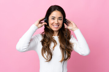 Fototapeta premium Woman over isolated pink background listening music