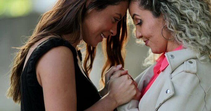 Two happy women holding hands and embrace, girlfriends hugging