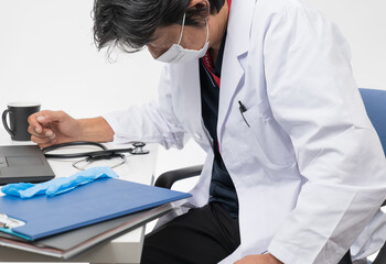 忙しすぎて疲れている中年男性医師