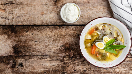 Sorrel soup with egg in bowl on the wooden table. Traditional Latvian soup. Skabenu zupa, banner, menu recipe place for text, top view