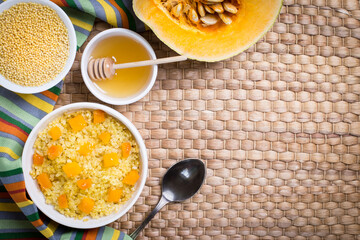 Millet porridge with pumpkin slices on a wicker napkin.