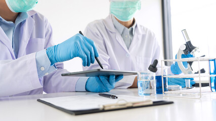 Team of Medical Research Scientists or researcher in lab coat testing their experimental in Modern...