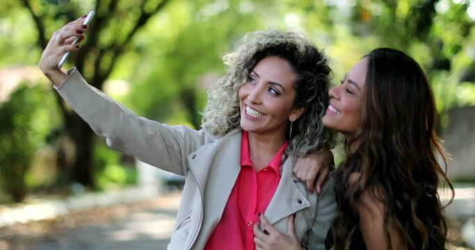 Two friends taking selfie together. Women taking photo with smartphone