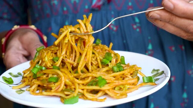 Woman's hand showing spaghetti in the dish at restaurant