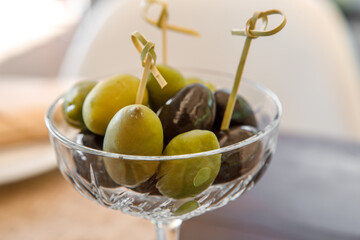 A bowl of olives is on the table.