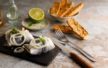 pickled herring on a plate. Seafood, pickled herring marinated in vinegar and onions on a plate. Served on a old wooden table top. Top view.