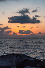 Obraz premium Summer Sunset on the Sorrentine Coast near Marina Lobra, Massa Lubrense, Italy with Boat Passing by in the Tyrrhenian Sea
