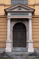 Obraz premium Entrance Door to Sieberersches Waisenhaus und Greisenasyl - Sieberer Orphanage and Elderly Asylum in Innsbruck, Tyrol, Austria with Sign reading 'Venite Adoremus' - 'Come let us adore him'