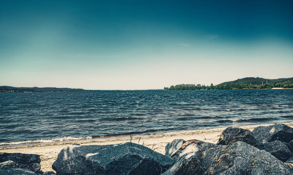 Strand am Zarnowitzer See in Lubkowo am Jezioro Żarnowieckie im Sommer bei wolkenlosem Himmel. Bucht und Ufer im Sommer am Sandstrand in Polen.