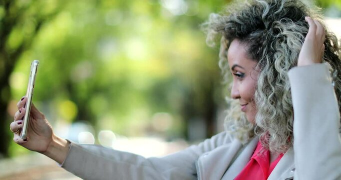 Woman taking selfie with phone camera outside of herself