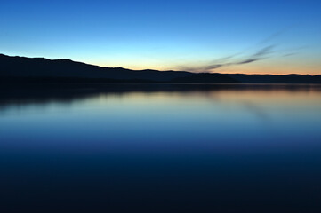 美しいグラデーションの空を静水の湖面に映す夕暮れの湖。