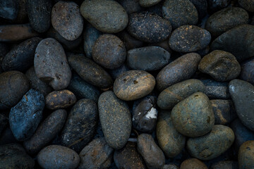 Fototapeta na wymiar Small stone texture for background. Group of brown, grey and black pebbles, flat lay texture in daylight
