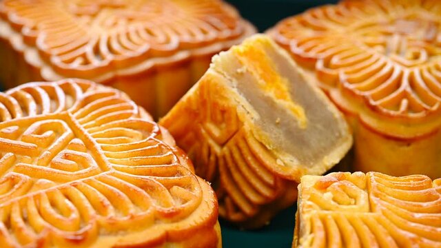 angle view square shape traditional mooncakes with a piece cut out rotating