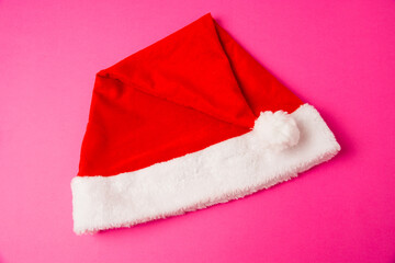 Obraz na płótnie Canvas Santa claus hat on pink background close up copy space