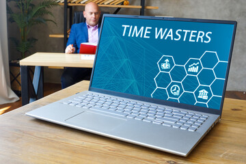 Financial concept about TIME WASTERS with inscription on the computer.
