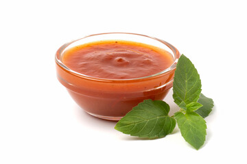 Bowl of tomato sauce with green mint leaf, isolated on white background.