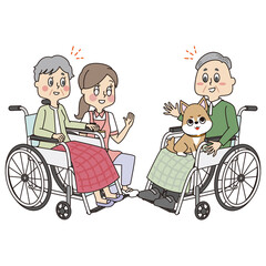 ドッグセラピーを受ける車椅子のシニアの男性と女性と見守る女性ヘルパー