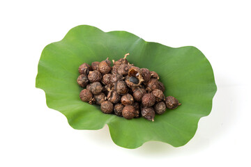Dried sapindus rarak fruits on lotus leaf and isolated on white background.