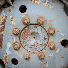 Close-up of tractor wheel mountings. Selective focus on the mounting bolts. Old rusty wheel. Rural life