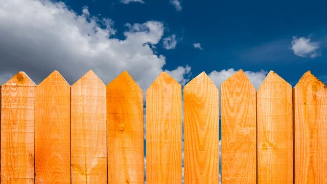 wooden fence on blue cloudy sky background