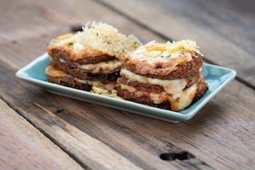 Fototapeta na wymiar Pan fried crispy eggplant with parmesan cheese crust isolated on wooden table