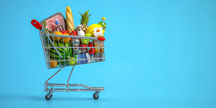 Shopping cart full of food on blue background. Grocery and food store concept.