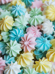 Fototapeta na wymiar Close-up delicious meringue cookies pastel colors background