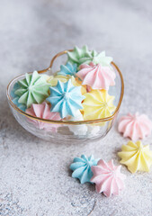 Small colorful meringues in the  heart shaped bowl