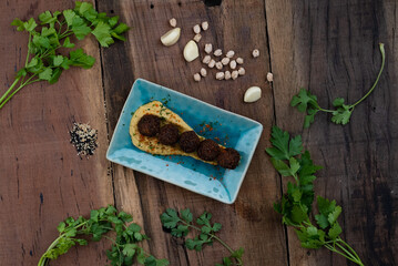Bite sized falafel of chickpea, onion, sesame seeds served with a garlic hummus dip isolated on rustic wooden table