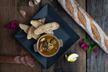 Top view of Gambas Pil Pil - Sizzling prawns with chili and garlic served with bread on the side isolated on wooden rustic table