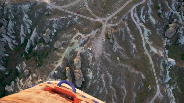 Beautiful scenic landscapes of Cappadocia, Goreme, Turkey. 4k point of view stock video footage of colorful hot air balloons flying in morning at sunrise time. View down from basket of air balloon