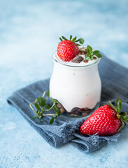 Natural yogurt with granola and strawberry for breakfast or snack. Healthy eating concept. 