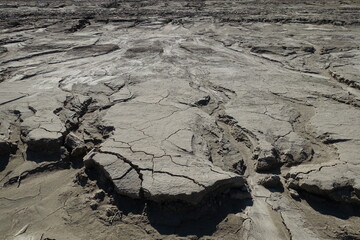 Water-washed land. Cracked crumbling clay and sandy soil after the snow melts in the spring or flood. concept of soil erosion climate change and sudden changes in air temperature and natural disasters