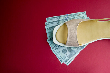 women's shoe on souvenir dollars and on a red background