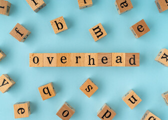 Overhead word on wooden block. Flat lay view on blue background.