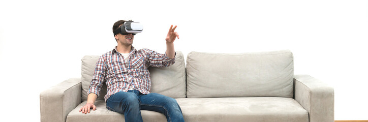 Fototapeta premium The man in virtual glasses sitting on the sofa on the white wall background