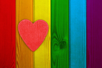 On a wooden textured background of rainbow-colored boards of the LGBT sign is a red heart.It can be used as a border of pride of the gay and lesbian community,for the design of leaflets,greeting cards