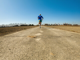 Obraz premium Male runner exercising on countryside road