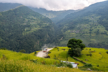 Local bus driving on steep and dangerous hill road on mountains edge to Ghandruk village, Nepal....