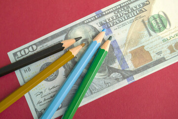 multicolored pencils on souvenir dollar bills