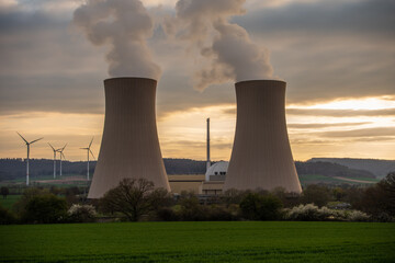 Nuclear power plant against sky at sunset.